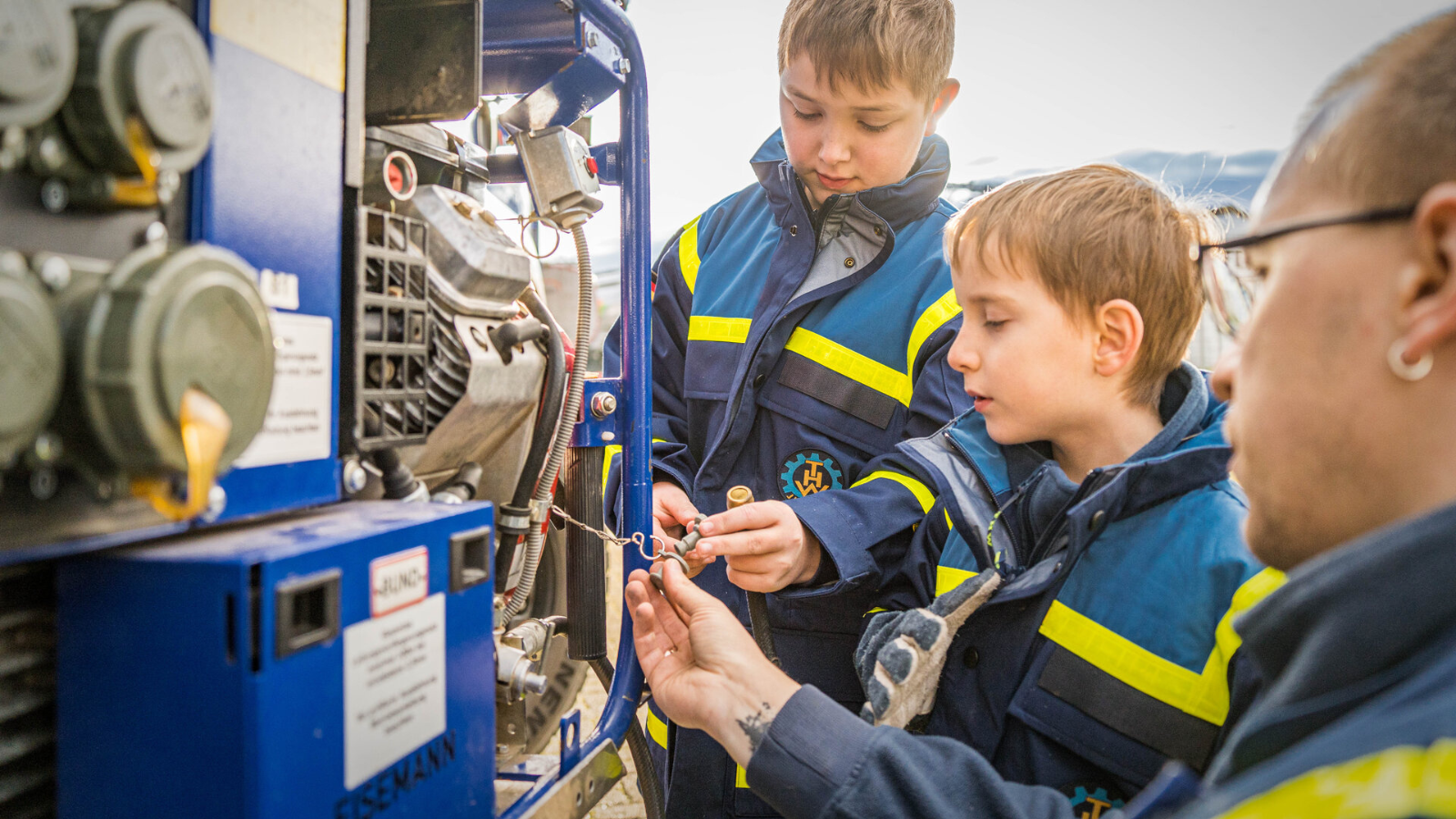 Ein Mann erklärt Kindern ein technisches Gerät.