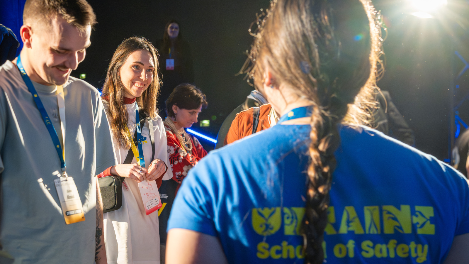 Eine Teilnehmerin der Schule der Sicherheit redet mit zwei jungen Menschen.